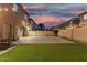 Spacious backyard featuring artificial grass, brick pavers, and string lights at 9350 W Williams St, Tolleson, AZ 85353