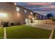 Spacious backyard featuring artificial grass, brick pavers, and string lights at 9350 W Williams St, Tolleson, AZ 85353