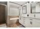 Bathroom featuring double sinks with black hardware and a bathtub with tile surround at 9350 W Williams St, Tolleson, AZ 85353