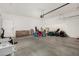 Spacious garage with a concrete floor and lots of stored items and a white door at 9350 W Williams St, Tolleson, AZ 85353