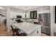 Well-lit kitchen with white cabinetry, stainless steel appliances, a quartz island, and tile backsplash at 9350 W Williams St, Tolleson, AZ 85353