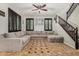 Spacious living room with a large sectional couch, striking tile floor, and elegant ceiling fan at 9350 W Williams St, Tolleson, AZ 85353