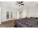 This main bedroom features a ceiling fan and access to the backyard through French doors at 9350 W Williams St, Tolleson, AZ 85353