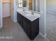 Bathroom with double vanity sinks, modern cabinetry, and a view into the walk-in closet at 9412 E Sequence Ave, Mesa, AZ 85212