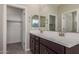 Bathroom with a double sink vanity, large mirror and a walk in closet at 9412 E Sequence Ave, Mesa, AZ 85212