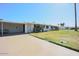 A well-maintained house with a green lawn, covered parking, and mature landscaping at 10307 W Oakmont Dr, Sun City, AZ 85351
