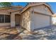 Close-up of front entrance with beige siding, two-car garage and tiled roof details at 10956 E Delta Ave, Mesa, AZ 85208