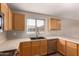 Well-lit kitchen features wood cabinets, laminate countertops, and black double basin sink at 10956 E Delta Ave, Mesa, AZ 85208