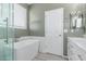 Modern bathroom with a soaking tub, dual sink vanity, and a separate shower at 11836 W Planada Ct, Sun City, AZ 85373