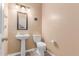Half bathroom features a pedestal sink, toilet, and neutral paint at 11836 W Planada Ct, Sun City, AZ 85373