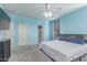Light-filled primary bedroom boasts a ceiling fan, TV, ensuite bathroom, and plush carpet at 11836 W Planada Ct, Sun City, AZ 85373