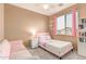 Cozy bedroom featuring pink accents, plush carpet, and a window with blinds at 11836 W Planada Ct, Sun City, AZ 85373