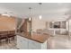 Open floor plan featuring kitchen island with seating, dining area, staircase and living room at 11836 W Planada Ct, Sun City, AZ 85373