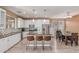 Open concept kitchen with white cabinets, stainless appliances, island with seating, and adjacent dining area at 11836 W Planada Ct, Sun City, AZ 85373