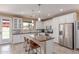Bright kitchen features white cabinetry, stainless steel appliances, and large island with bar seating at 11836 W Planada Ct, Sun City, AZ 85373