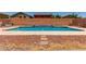 Beautiful in-ground pool with brick surround, tile accents, and red rock landscaping offering a private backyard at 11836 W Planada Ct, Sun City, AZ 85373