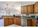 Traditional kitchen with wooden cabinetry, stainless steel dishwasher, and a double-basin sink at 1350 S Greenfield Rd # 1130, Mesa, AZ 85206