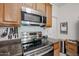 Kitchen showcasing stainless steel microwave, range, and overhead exhaust fan at 1350 S Greenfield Rd # 1130, Mesa, AZ 85206