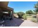 A covered patio overlooks a backyard featuring mature trees and desert landscaping at 1350 S Greenfield Rd # 1130, Mesa, AZ 85206