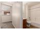 Bright bathroom featuring a tub with shower, tile surround, and wood vanity at 15440 W Mauna Loa Ln, Surprise, AZ 85379