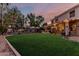 Spacious backyard with covered patio, string lights, and lush green lawn, perfect for entertaining at 1571 E Saratoga Ct, Gilbert, AZ 85296