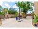Open backyard patio with sitting area, colorful potted plants, and mature landscaping at 1571 E Saratoga Ct, Gilbert, AZ 85296