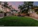 Picturesque backyard with green lawn, trampoline, and mature trees offering privacy at 1571 E Saratoga Ct, Gilbert, AZ 85296