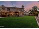 A sprawling backyard with well-maintained lawn, patio, and elegant lighting enhances the property's charm at 1571 E Saratoga Ct, Gilbert, AZ 85296