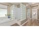 Well-lit bathroom with a large tub, shower with glass block wall and wood-look flooring at 1571 E Saratoga Ct, Gilbert, AZ 85296