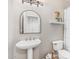 Bathroom with pedestal sink and unique decorations next to a toilet at 1571 E Saratoga Ct, Gilbert, AZ 85296