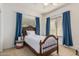 Cozy bedroom featuring a wooden bed frame, large windows, and calming blue curtains at 1571 E Saratoga Ct, Gilbert, AZ 85296