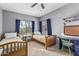 Bedroom featuring two wooden twin beds, a window with blinds and blue curtains, and a blue desk at 1571 E Saratoga Ct, Gilbert, AZ 85296