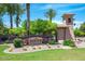 Silver Stone Ranch community entrance with desert landscaping, tower, and palm trees on a sunny day at 1571 E Saratoga Ct, Gilbert, AZ 85296