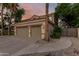 Exterior showcasing a spacious home with a three-car garage and lush tropical landscaping at 1571 E Saratoga Ct, Gilbert, AZ 85296