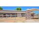 Angled view of horse barn and horse in a stall, with stacked rock support posts and metal gates under a blue sky at 1571 E Saratoga Ct, Gilbert, AZ 85296