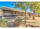 Distant view of stalls in the horse barn, with a horse in one stall and desert landscaping, under a blue sky at 1571 E Saratoga Ct, Gilbert, AZ 85296