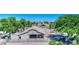 Overhead view of horse barn, stalls and paddocks with desert landscaping and lush green trees under a blue sky at 1571 E Saratoga Ct, Gilbert, AZ 85296