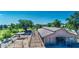 Aerial view of horse barn showing covered stalls and adjacent paddocks, with lush green trees under a blue sky at 1571 E Saratoga Ct, Gilbert, AZ 85296