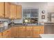 Well-lit kitchen featuring classic wood cabinetry, gray countertops, and a view of the backyard at 1571 E Saratoga Ct, Gilbert, AZ 85296