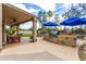 Outdoor kitchen and dining area under a covered patio, overlooking a lush yard at 1571 E Saratoga Ct, Gilbert, AZ 85296