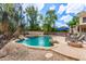 Tranquil pool area with lush greenery, a waterfall feature, and a cozy fire pit, ideal for relaxation at 1571 E Saratoga Ct, Gilbert, AZ 85296