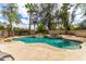 Resort-style pool with rock waterfall feature, tropical landscaping, and spacious sunbathing area at 1571 E Saratoga Ct, Gilbert, AZ 85296