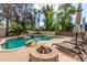 The backyard includes a custom pool with waterfall, fire pit, and lounge chairs, perfect for outdoor gatherings at 1571 E Saratoga Ct, Gilbert, AZ 85296