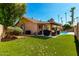 Spacious backyard featuring a covered patio, manicured lawn, and a variety of trees, perfect for outdoor activities at 1630 W Calle Del Norte --, Chandler, AZ 85224