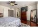 Bedroom featuring wood floors, ceiling fan, television and an archway leading to the Primary bathroom at 1630 W Calle Del Norte --, Chandler, AZ 85224