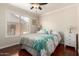 Cozy bedroom with wood floors, ceiling fan, a large window with natural light, and furnishings at 1630 W Calle Del Norte --, Chandler, AZ 85224