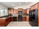 Modern kitchen featuring dark wood cabinetry, granite countertops, and black appliances, offering style and functionality at 1630 W Calle Del Norte --, Chandler, AZ 85224