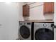 Well-equipped laundry room with modern washer and dryer set and upper cabinetry at 1630 W Calle Del Norte --, Chandler, AZ 85224