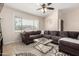 Cozy living room with large windows, a ceiling fan, and a comfortable sectional sofa, perfect for relaxation at 1630 W Calle Del Norte --, Chandler, AZ 85224