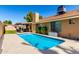 Secluded backyard pool with patio, covered seating area, manicured lawn, and attractive exterior architecture at 1630 W Calle Del Norte --, Chandler, AZ 85224